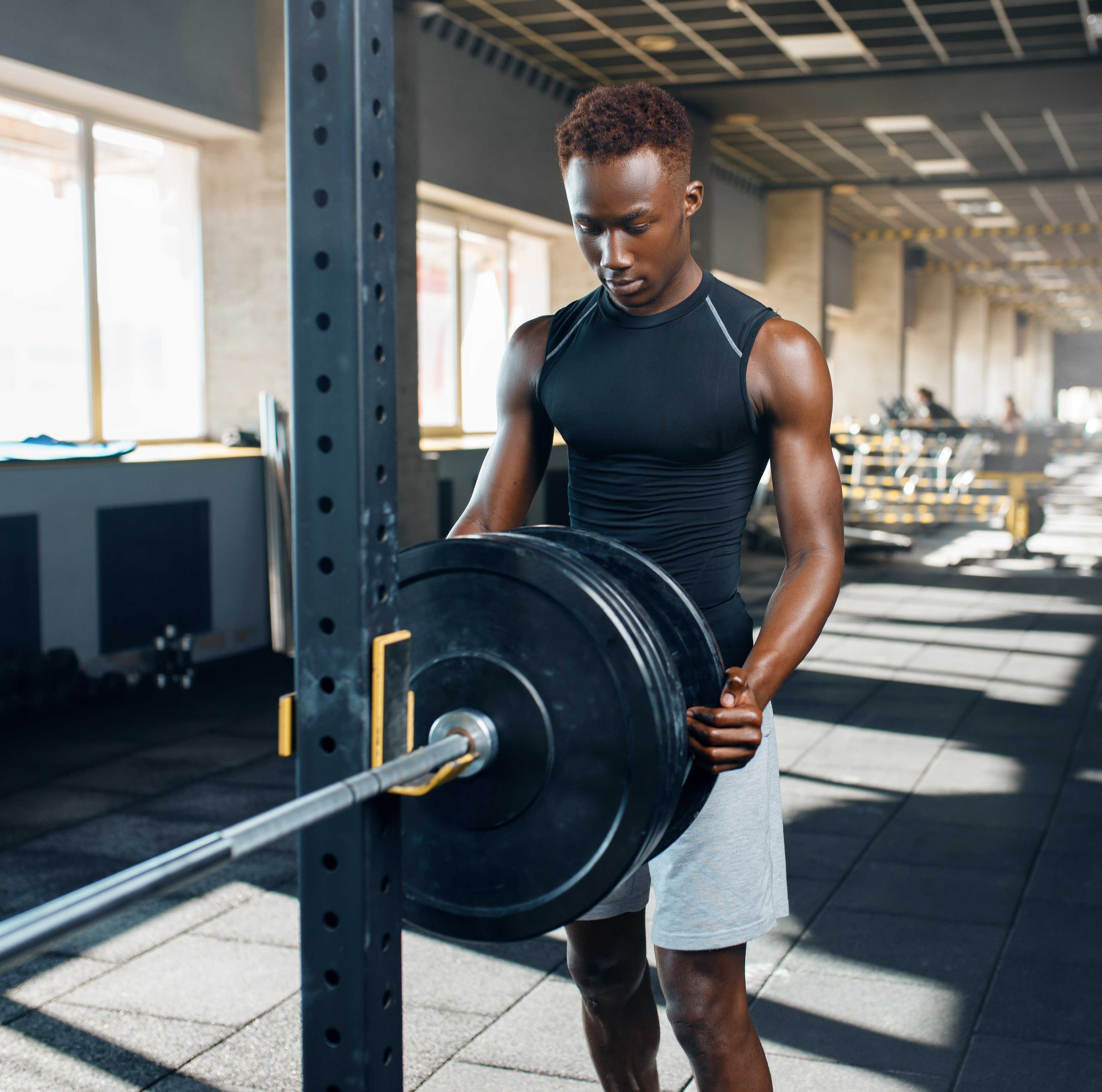 muscular-man-in-sportswear-prepares-barbell-in-gym-2024-12-07-05-54-58-utc-1